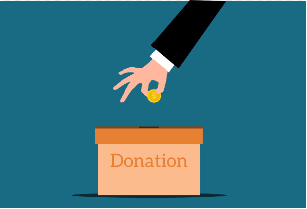Dropping coin into a donation box